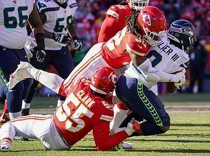 Dec 24, 2022; Kansas City, Missouri, USA; Seattle Seahawks running back Kenneth Walker III (9) is tackled by Kansas City Chiefs defensive end Frank Clark (55) and linebacker Nick Bolton (32) during the first half at GEHA Field at Arrowhead Stadium. Mandatory Credit: Denny Medley-USA TODAY Sports
