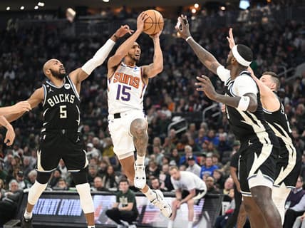 Feb 26, 2023; Milwaukee, Wisconsin, USA; Phoenix Suns guard Cameron Payne (15) puts up a shot against Milwaukee Bucks guard Jevon Carter (5) in the first half at Fiserv Forum. Mandatory Credit: Michael McLoone-USA TODAY Sports