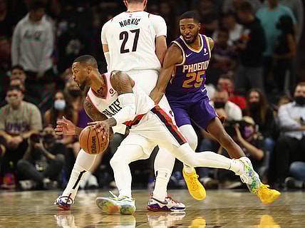 Nov 10, 2021; Phoenix, Arizona, USA; Portland Trail Blazers guard Damian Lillard (0) moves the ball against Phoenix Suns forward Mikal Bridges (25) in the first half at Footprint Center. Mandatory Credit: Mark J. Rebilas-USA TODAY Sports
