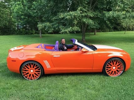 Vic Beasley smiling while sitting in his Clemson-themed Camaro