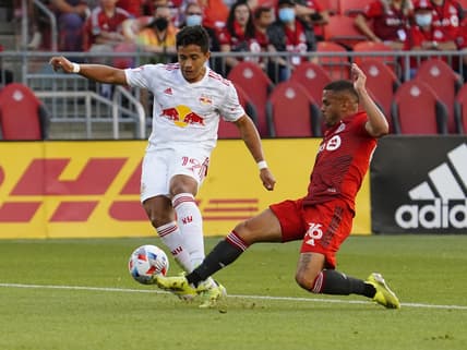 Jul 21, 2021; Toronto, Ontario, CAN; Toronto FC defender Auro (96) kicks the ball away from New York Red Bulls midfielder Wikelman Carmona (19) during the first half at BMO Field. Mandatory Credit: John E. Sokolowski-USA TODAY Sports