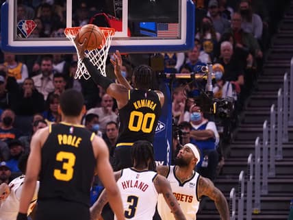 Feb 16, 2022; San Francisco, California, USA; Golden State Warriors forward Jonathan Kuminga (00) scores a basket above Denver Nuggets center DeMarcus Cousins (4) during the first quarter at Chase Center. Mandatory Credit: Kelley L Cox-USA TODAY Sports