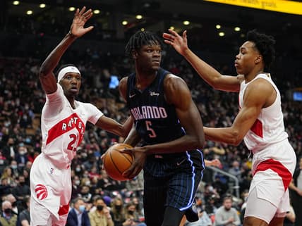 Mar 4, 2022; Toronto, Ontario, CAN; Toronto Raptors forward Chris Boucher (25) and forward Scottie Barnes (4) defend against Orlando Magic center Mo Bamba (5) during the first half at Scotiabank Arena. Mandatory Credit: John E. Sokolowski-USA TODAY Sports