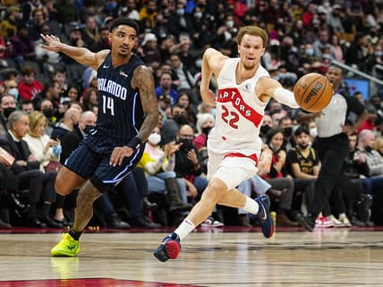 Mar 4, 2022; Toronto, Ontario, CAN; Toronto Raptors guard Malachi Flynn (22) drives to the basket against Orlando Magic guard Gary Harris (14) during the first half at Scotiabank Arena. Mandatory Credit: John E. Sokolowski-USA TODAY Sports