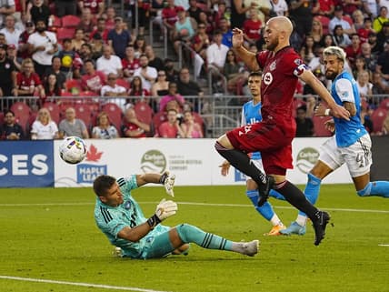 Jul 23, 2022; Toronto, Ontario, CAN; Toronto FC midfielder Michael Bradley (4) scores on Charlotte FC goalkeeper Kristijan Kahlina (1) during the first half at BMO Field. Mandatory Credit: John E. Sokolowski-USA TODAY Sports