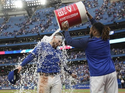 Oct 1, 2022; Toronto, Ontario, CAN; Toronto Blue Jays first baseman Vladimir Guerrero Jr., right, dumps a bucket of ice water over catcher Danny Jansen after a win over the Boston Red Sox at Rogers Centre. Mandatory Credit: John E. Sokolowski-USA TODAY Sports