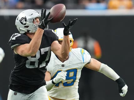 Dec 4, 2022; Paradise, Nevada, USA; Las Vegas Raiders tight end Foster Moreau (87) makes a catch ahead of Los Angeles Chargers linebacker Drue Tranquill (49) during the first half at Allegiant Stadium. Mandatory Credit: Stephen R. Sylvanie-USA TODAY Sports