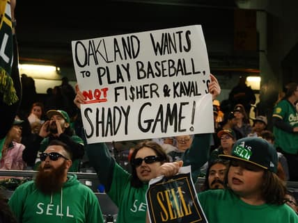 Apr 28, 2023; Oakland, California, USA; An Oakland Athletics fan holds a sign in reference to owner John Fisher and president Dave Kaval (not pictured) during the sixth inning against the Cincinnati Reds at Oakland Coliseum. Mandatory Credit: Kelley L Cox-USA TODAY Sports