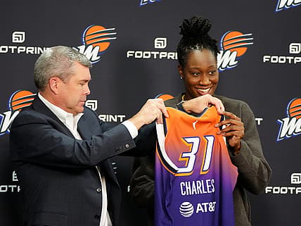 Feb 10, 2022; Phoenix, Arizona, USA; Phoenix Mercury general manager Jim Pitman (left) and Tina Charles hold up her jersey during Charles    introductory press conference at Footprint Center. Mandatory Credit: Patrick Breen-The Republic