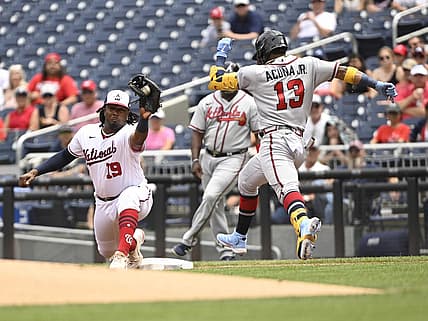 Jul 17, 2022; Washington, District of Columbia, USA;  Washington Nationals first baseman Josh Bell (19) reaches to make a catch at first base as Atlanta Braves right fielder Ronald Acuna Jr. (13) stretches for the base during the first inning at Nationals Park. Mandatory Credit: James A. Pittman-USA TODAY Sports