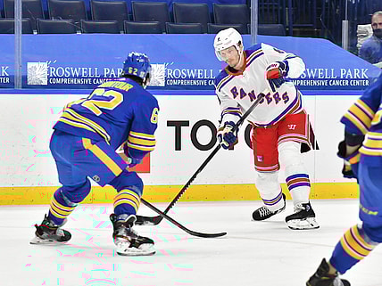 Jan 26, 2021; Buffalo, New York, USA; New York Rangers defenseman Jacob Trouba (8) looks to move the puck past Buffalo Sabres defenseman Brandon Montour (62) in the first period of a game at KeyBank Center. Mandatory Credit: Mark Konezny-USA TODAY Sports