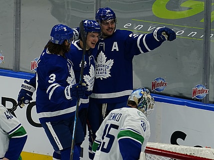Feb 4, 2021; Toronto, Ontario, CAN; Toronto Maple Leafs forward Auston Matthews (34) celebrates his second goal of the game against Vancouver Canucks goaltender Thatcher Demko (35) with Toronto Maple Leafs forward Zach Hyman (11) and defenseman Justin Holl (3) during the second period at Scotiabank Arena. Mandatory Credit: John E. Sokolowski-USA TODAY Sports