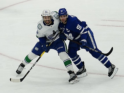 Feb 4, 2021; Toronto, Ontario, CAN; Vancouver Canucks defenseman Jalen Chatfield (63) and Toronto Maple Leafs forward John Tavares (91) battle for position during the third period at Scotiabank Arena. Toronto defeated Vancouver. Mandatory Credit: John E. Sokolowski-USA TODAY Sports