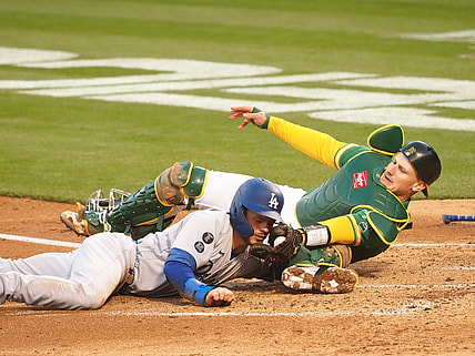 Apr 6, 2021; Oakland, California, USA; Oakland Athletics catcher Sean Murphy (12) tags out Los Angeles Dodgers second baseman Gavin Lux (9) at home during the second inning at RingCentral Coliseum. Mandatory Credit: Kelley L Cox-USA TODAY Sports