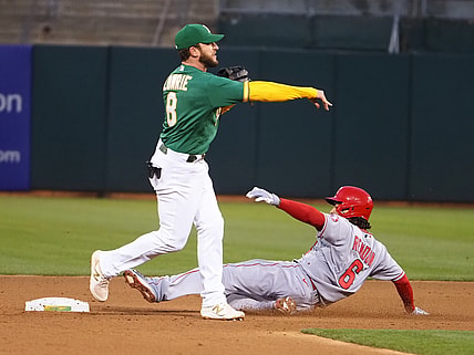 May 28, 2021; Oakland, California, USA; Oakland Athletics second baseman Jed Lowrie (8) turns a double play against Los Angeles Angels third baseman Anthony Rendon (6) during the sixth inning at RingCentral Coliseum. Mandatory Credit: Kelley L Cox-USA TODAY Sports