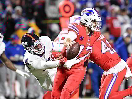 Oct 15, 2023; Orchard Park, New York, USA; Buffalo Bills quarterback Josh Allen (17) tries to avoid a tackle by New York Giants linebacker Kayvon Thibodeaux (5) in the third quarter at Highmark Stadium. Mandatory Credit: Mark Konezny-USA TODAY Sports