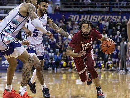 Feb 26, 2022; Seattle, Washington, USA; Washington State guard Michael Flowers (12) attempts to drive past Washington forward Nate Roberts (1), left, and guard Jamal Bey (5) during the second half at Alaska Airlines Arena at Hec Edmundson Pavilion. Mandatory Credit: Stephen Brashear-USA TODAY Sports