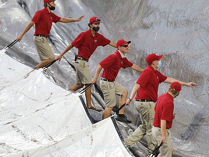 Jun 29, 2021; Cincinnati, Ohio, USA; Cincinnati Reds ground crew members uncover the field after a short rain delay prior to a game with the San Diego Padres and the Cincinnati Reds at Great American Ball Park. Mandatory Credit: David Kohl-USA TODAY Sports