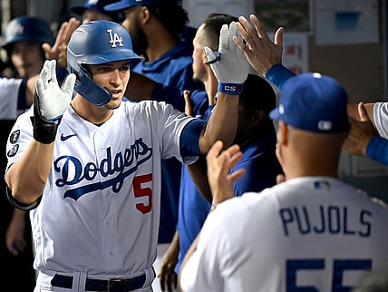 Aug 30, 2021; Los Angeles, California, USA;  Los Angeles Dodgers shortstop Corey Seager (5) is greeted in the dugout after hitting a two run home scoring left fielder AJ Pollock (11) run in the third inning of the game against the Atlanta Braves at Dodger Stadium. Mandatory Credit: Jayne Kamin-Oncea-USA TODAY Sports