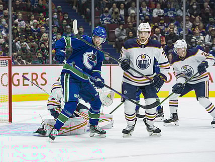 Oct 30, 2021; Vancouver, British Columbia, CAN; Vancouver Canucks forward Elias Pettersson (40) and Edmonton Oilers defenseman Evan Bouchard (75) battle for the loose puck in the first period at Rogers Arena. Mandatory Credit: Bob Frid-USA TODAY Sports