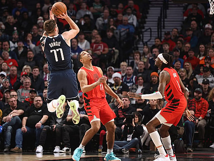 Dec 16, 2023; Portland, Oregon, USA; Dallas Mavericks guard Luka Doncic (77) shoots the ball after drawing a foul against Portland Trail Blazers guard Malcolm Brogdon (11)  in the first half at Moda Center. Mandatory Credit: Jaime Valdez-USA TODAY Sports