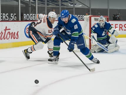 May 3, 2021; Vancouver, British Columbia, CAN; Edmonton Oilers forward Jesse Puljujarvi (13) defends Vancouver Canucks defenseman Nate Schmidt (88) in the first period at Rogers Arena. Mandatory Credit: Bob Frid-USA TODAY Sports
