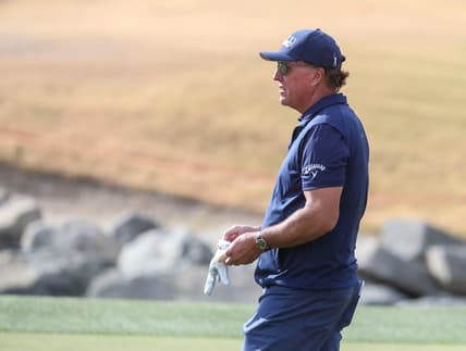 Phil Mickelson gives advice to an amateur in his group while playing the 11th green of the Pete Dye Stadium course during the third round of The American Express at PGA West in La Quinta, Calif., Saturday, Jan. 22, 2022.