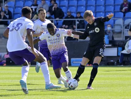 May 7, 2022; Montreal, Quebec, CAN; CF Montreal midfielder Djordje Mihailovic (right) controls the ball against Orlando City SC midfielder Jhegson Sebastian Mendez (middle) during the first half at Stade Saputo. Mandatory Credit: Eric Bolte-USA TODAY Sports