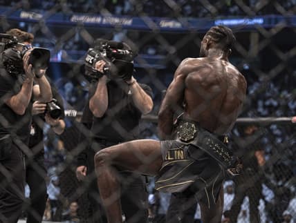 Oct 22, 2022; Abu Dhabi, UAE; Aljamain Sterling (red gloves) celebrates with the title belt after defeating T.J. Dillashaw (blue gloves) during UFC 280 at Etihad Arena. Mandatory Credit: Craig Kidwell-USA TODAY Sports