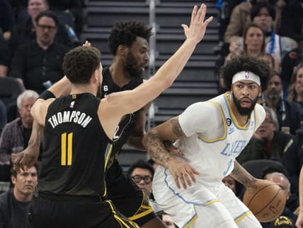 February 11, 2023; San Francisco, California, USA; Los Angeles Lakers forward Anthony Davis (3) dribbles the basketball against Golden State Warriors guard Klay Thompson (11) and forward Andrew Wiggins (22) during the second quarter at Chase Center. Mandatory Credit: Kyle Terada-USA TODAY Sports