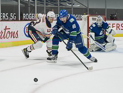 May 3, 2021; Vancouver, British Columbia, CAN; Edmonton Oilers forward Jesse Puljujarvi (13) defends Vancouver Canucks defenseman Nate Schmidt (88) in the first period at Rogers Arena. Mandatory Credit: Bob Frid-USA TODAY Sports