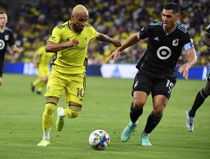 Aug 14, 2022; Nashville, Tennessee, USA; Nashville SC midfielder Hany Mukhtar (10) handles the ball against Minnesota United FC defender Michael Boxall (15) during the second half at Geodis Park. Mandatory Credit: Christopher Hanewinckel-USA TODAY Sports