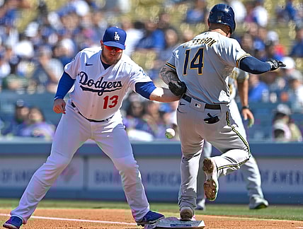 Oct 3, 2021; Los Angeles, California, USA;  Los Angeles Dodgers first baseman Max Muncy (13) makes a tag against Milwaukee Brewers second baseman Jace Peterson (14) on a throw from Dodgers shortstop Trea Turner (not pictured) in the third inning at Dodger Stadium. Muncy left the game with an apparent injury to his left arm. Mandatory Credit: Jayne Kamin-Oncea-USA TODAY Sports