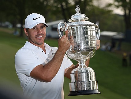 Brooks Koepka poses with the Wanamaker Trophy on the 18th green following his victory at the PGA Championship at Oak Hill Country Club Sunday, May 21, 2023.