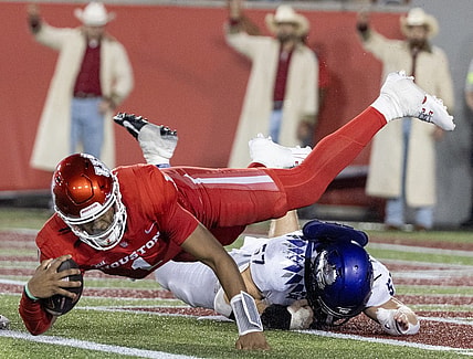 Sep 16, 2023; Houston, Texas, USA; Houston Cougars wide receiver Samuel Brown (4) is tackled by TCU Horned Frogs linebacker Johnny Hodges (57) on the one yard line in the second half at TDECU Stadium. Mandatory Credit: Thomas Shea-USA TODAY Sports