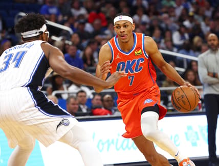 Mar 20, 2022; Orlando, Florida, USA; Oklahoma City Thunder forward Darius Bazley (7) drives to the basket as Orlando Magic center Wendell Carter Jr. (34) defends during the first quarter at Amway Center. Mandatory Credit: Kim Klement-USA TODAY Sports