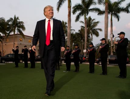President Donald Trump listens to the Palm Beach Central band as he arrives at Trump International Golf Club to watch the Super Bowl in West Palm Beach, Florida on February 5, 2017.