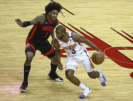 Apr 5, 2021; Houston, Texas, USA; Phoenix Suns guard Chris Paul (right) dribbles the ball against Houston Rockets guard Kevin Porter Jr. (left) during the third quarter at Toyota Center. Mandatory Credit: Troy Taormina-USA TODAY Sports