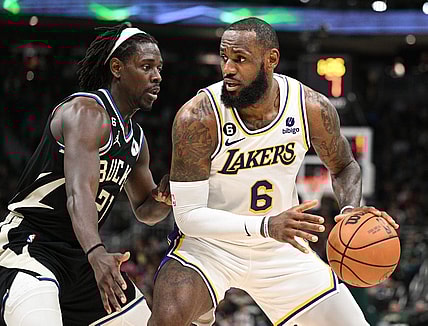 Dec 2, 2022; Milwaukee, Wisconsin, USA; Los Angeles Lakers forward LeBron James (6) posts up against Milwaukee Bucks guard Jrue Holiday (21) in the second quarter at Fiserv Forum. Mandatory Credit: Michael McLoone-USA TODAY Sports