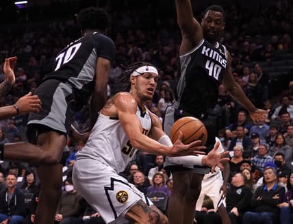 Mar 9, 2022; Sacramento, California, USA; Denver Nuggets forward Aaron Gordon (50) controls the ball between Sacramento Kings center Damian Jones (30) and forward Harrison Barnes (40) during the first quarter at Golden 1 Center. Mandatory Credit: Kelley L Cox-USA TODAY Sports