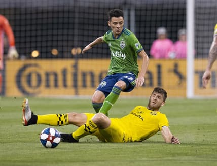 Jul 6, 2019; Columbus, OH, USA; Columbus Crew SC defender Gaston Sauro (22) tackles the ball away from Seattle Sounders forward Alfonso Ocampo-Chavez (87) at MAPFRE Stadium. Mandatory Credit: Greg Bartram-USA TODAY Sports