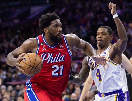 Dec 9, 2022; Philadelphia, Pennsylvania, USA; Philadelphia 76ers center Joel Embiid (21) drives past Los Angeles Lakers guard Lonnie Walker IV (4) during the first quarter at Wells Fargo Center. Mandatory Credit: Bill Streicher-USA TODAY Sports