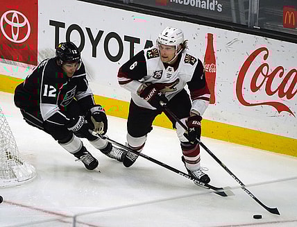 Apr 7, 2021; Los Angeles, California, USA; Arizona Coyotes defenseman Jakob Chychrun (6) moves the puck against Los Angeles Kings center Trevor Moore (12) during the first period at Staples Center. Mandatory Credit: Gary A. Vasquez-USA TODAY Sports