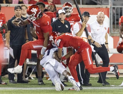 Sep 16, 2023; Houston, Texas, USA; Houston Cougars quarterback Donovan Smith (1) hurdles TCU Horned Frogs safety Bud Clark (21) in the second half at TDECU Stadium. Mandatory Credit: Thomas Shea-USA TODAY Sports