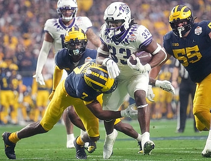 Dec 31, 2022; Glendale, Arizona, USA; TCU Horned Frogs running back Kendre Miller (33) tries to break away from Michigan Wolverines Makari Paige (7) past during the Vrbo Fiesta Bowl at State Farm Stadium. Mandatory Credit: Joe Rondone-Arizona Republic

Ncaa Fiesta Bowl Game