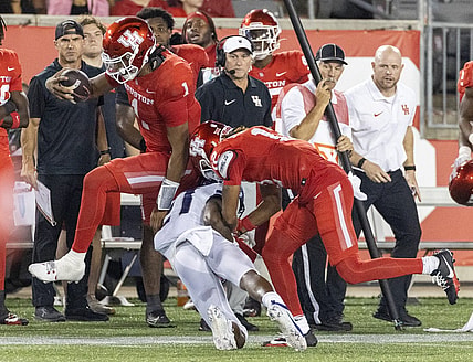 Sep 16, 2023; Houston, Texas, USA; Houston Cougars quarterback Donovan Smith (1) hurdles TCU Horned Frogs safety Bud Clark (21) in the second half at TDECU Stadium. Mandatory Credit: Thomas Shea-USA TODAY Sports