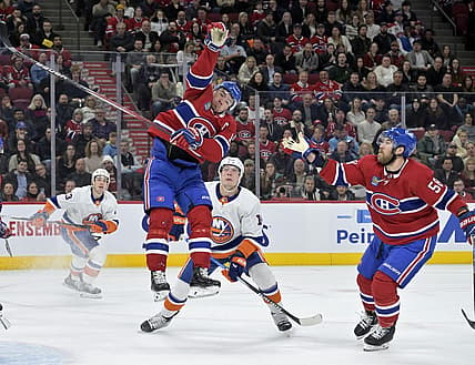 Dec 16, 2023; Montreal, Quebec, CAN; Montreal Canadiens forward Nick Suzuki (14) jumps to reach the puck during the first period of the game against the New York Islanders at the Bell Centre. Mandatory Credit: Eric Bolte-USA TODAY Sports