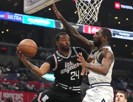 Nov 25, 2022; Los Angeles, California, USA; LA Clippers forward Norman Powell (24) passes the ball against Denver Nuggets guard Davon Reed (9) in the second half at Crypto.com Arena. Mandatory Credit: Kirby Lee-USA TODAY Sports