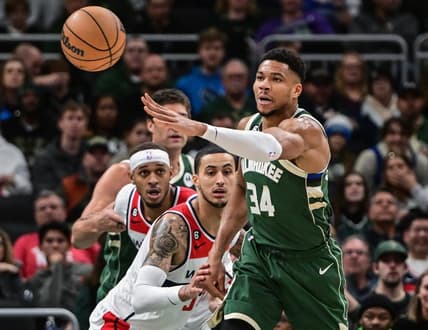 Jan 3, 2023; Milwaukee, Wisconsin, USA; Milwaukee Bucks forward Giannis Antetokounmpo (34) passes the ball away from Washington Wizards forward Kyle Kuzma (33) in the first quarter at Fiserv Forum. Mandatory Credit: Benny Sieu-USA TODAY Sports