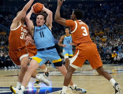 Marquette guard Tyler Kolek (11) is double-teamed b y Texas forward Brock Cunningham (30) and guard Max Abmas (3) during the first half of their game Wednesday, December 6, 2023 at Fiserv Forum in Milwaukee, Wisconsin.